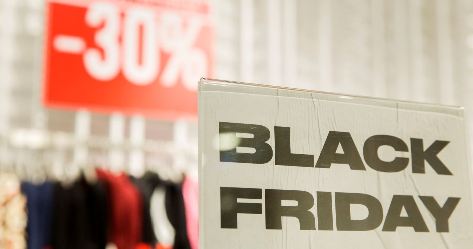 Black-Friday-Schild in einem Modegeschäft mit gut sichtbarem „–30 %“-Rabattplakat im Hintergrund.
