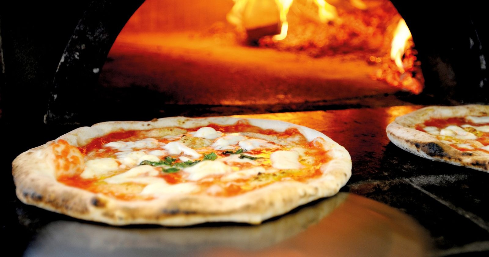 Frisch gebackene Pizza in einem heißen Steinofen mit offener Flamme – Symbolbild für den finanziell angeschlagenen Wiener Gastronomiebetrieb De Luca mit seinen Lokalen i Carusi und  i Trettoni