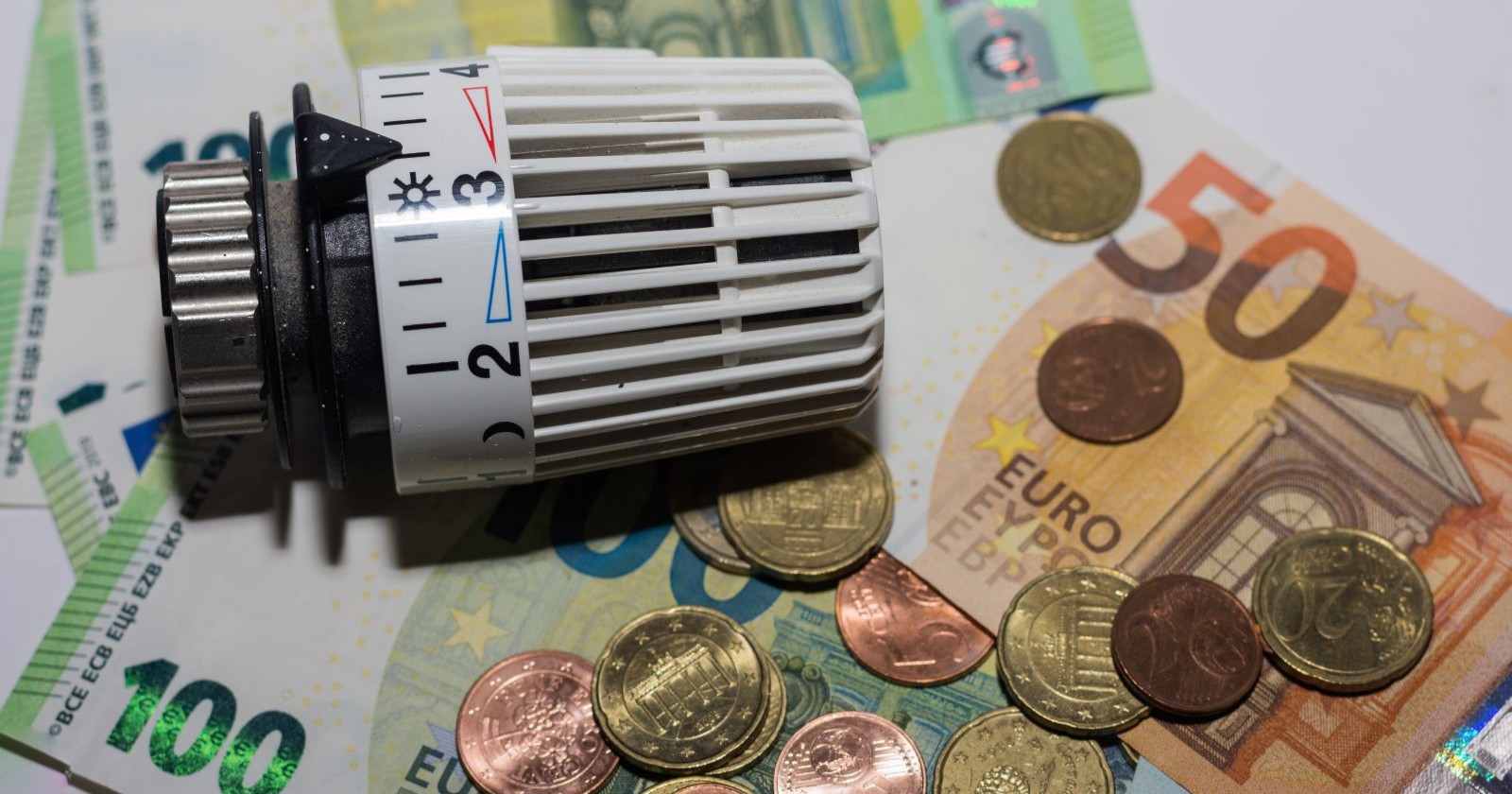 Heizungsregler auf Euro-Banknoten – Förderung für Kesseltausch und Sanierungsbonus 2026 in Österreich.