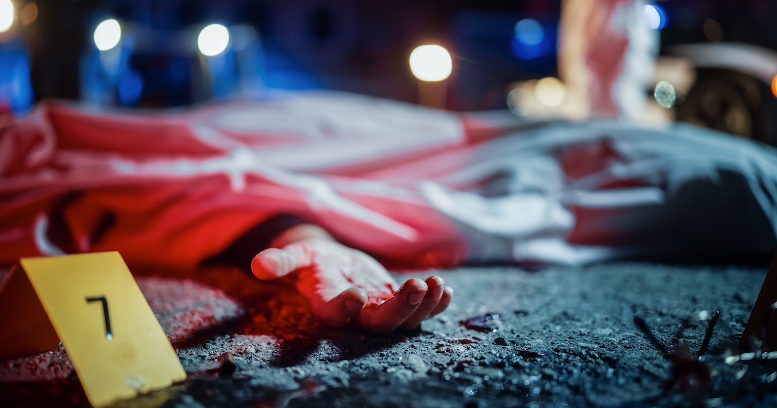 Foto eines Tatorts mit Person am Boden und Markierung