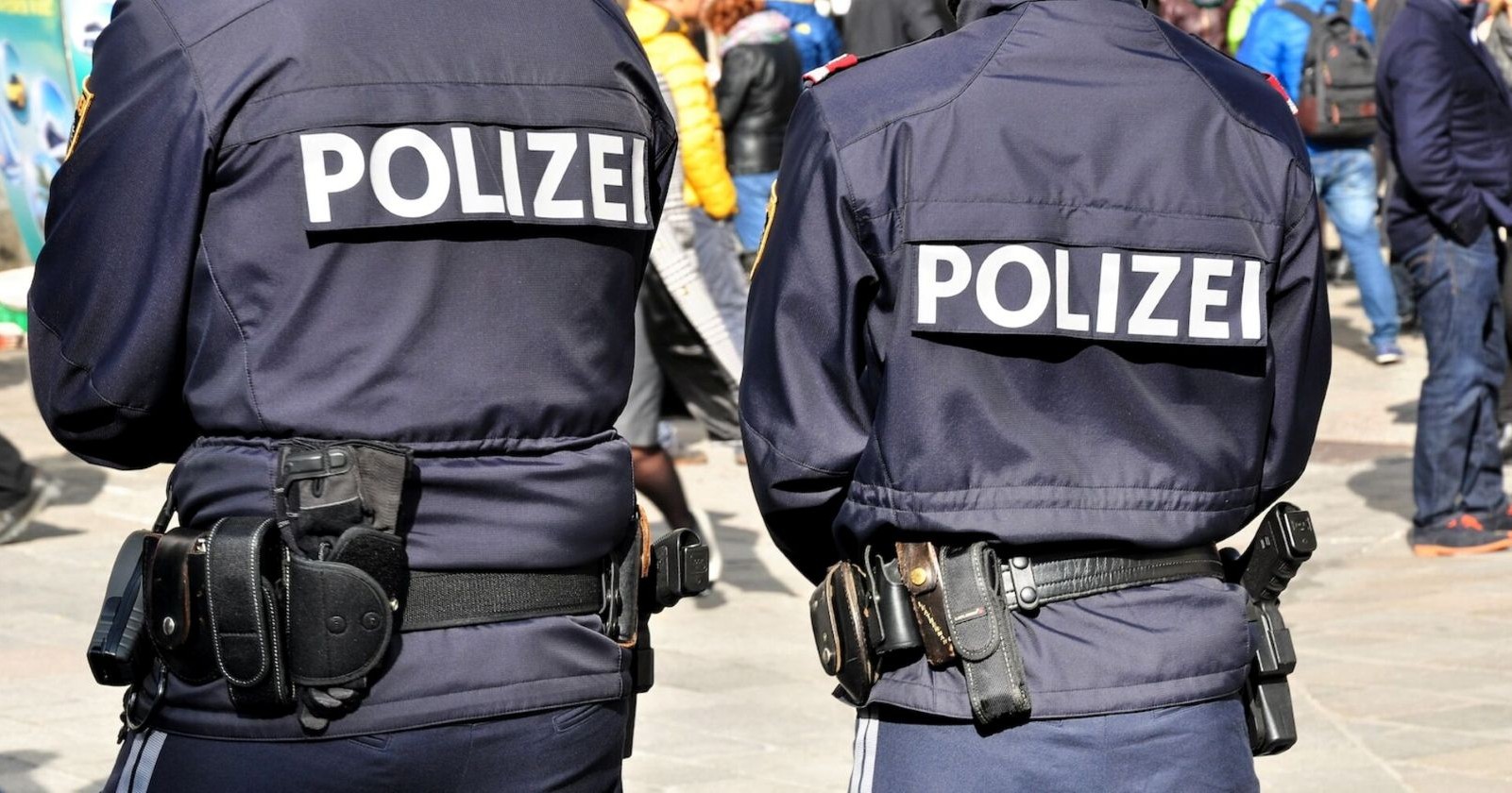 Zwei Polizisten in Montur stehen auf einer Straße
