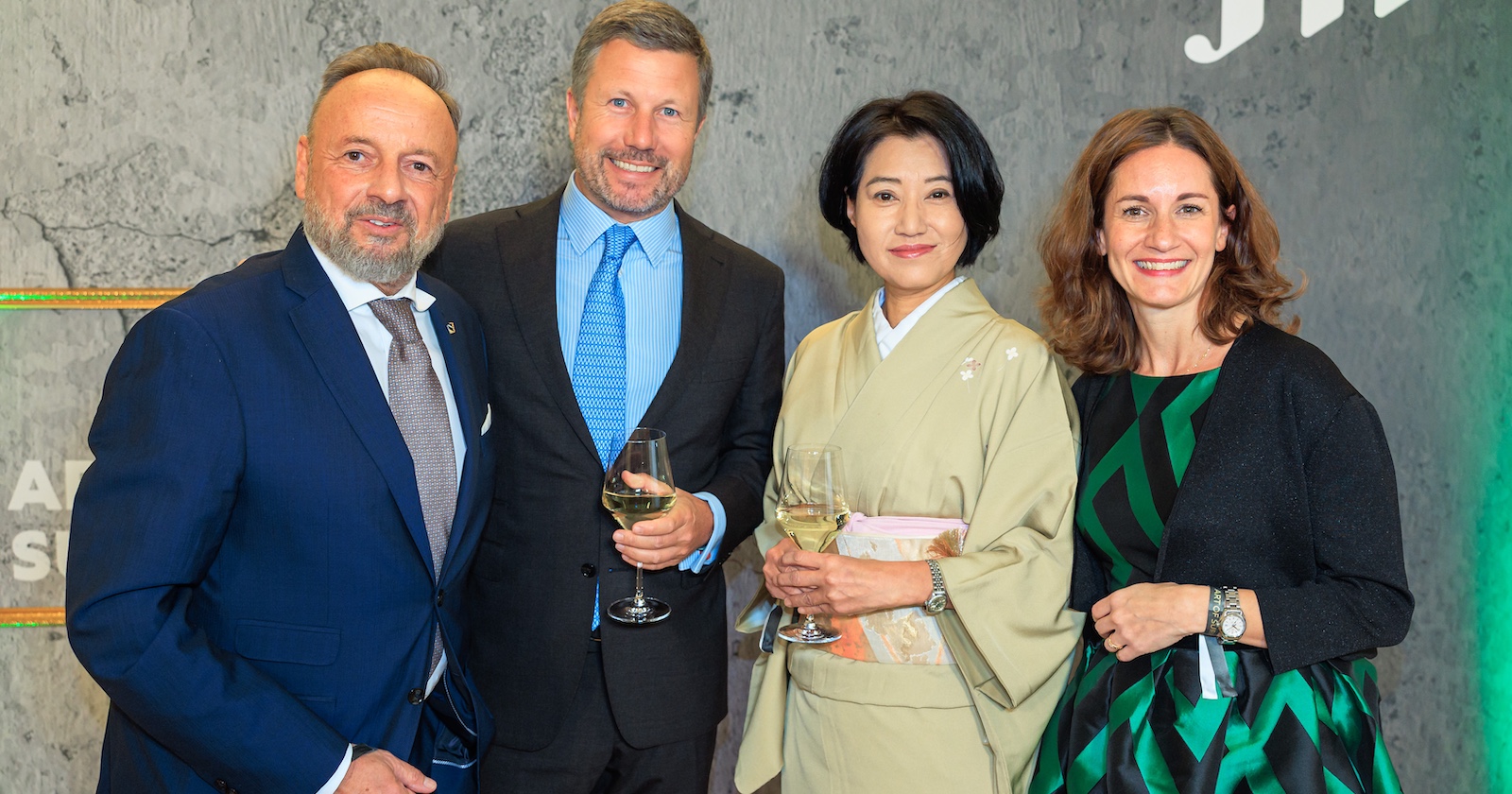 Quartett vor einer grauen Wand mit JTI-Logo