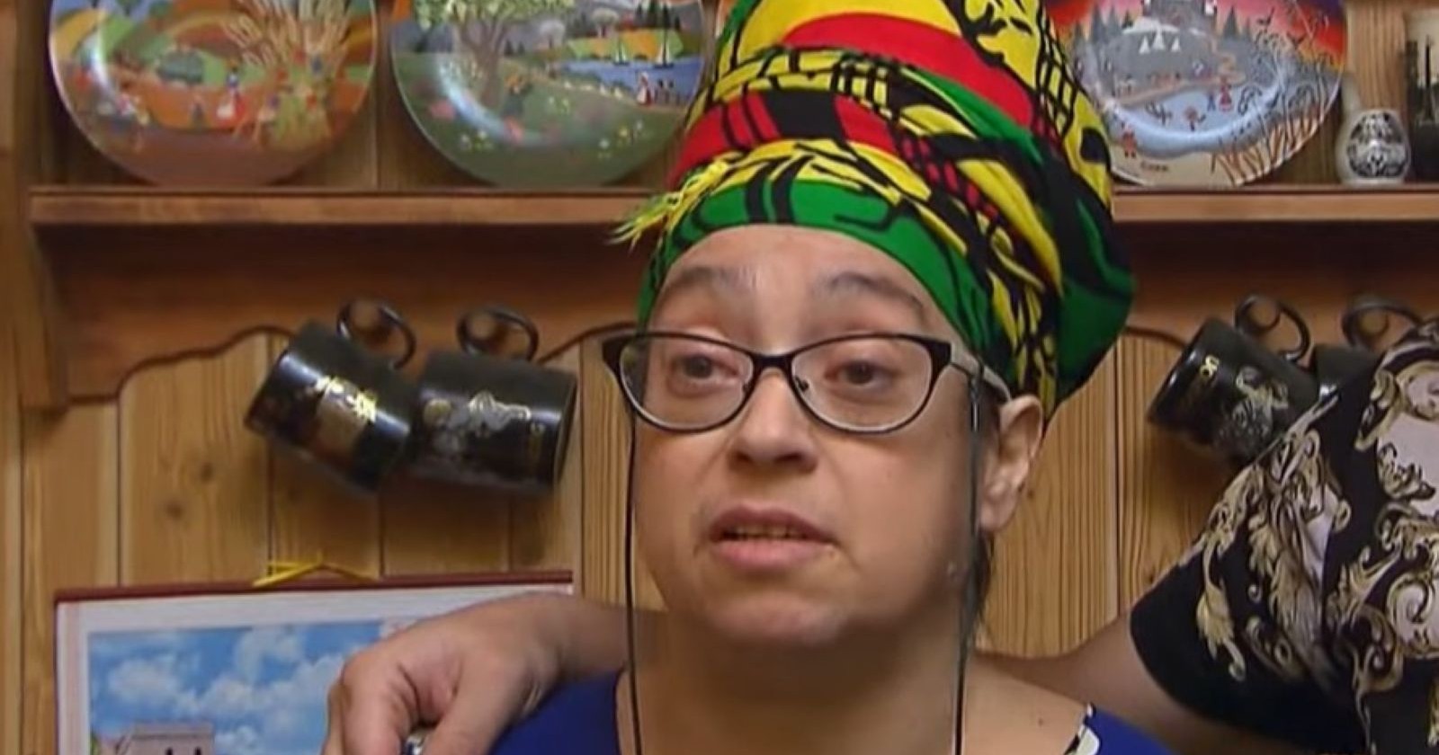 Manuela steht vor einer Küchenvitrine