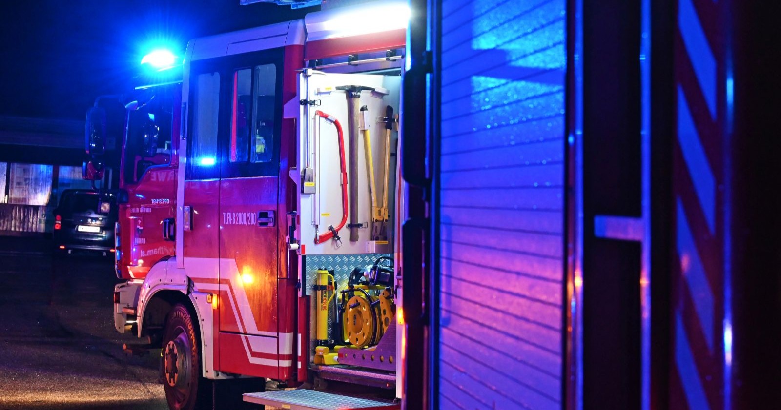 Feuerwehrwagen bei Nacht während eines Einsatzes mit eingeschalteter Sirene