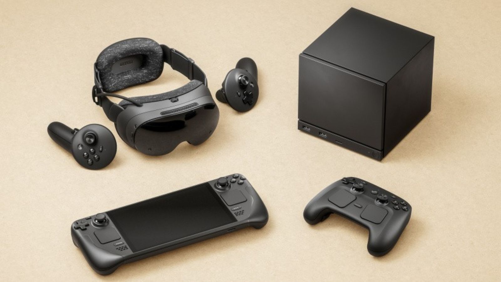 Schwarze Steam-Machine-Hardware auf hellem Untergrund: kompakte Konsolenbox, VR-Headset mit zwei Controllern, Steam-Handheld und neuer Steam Controller.