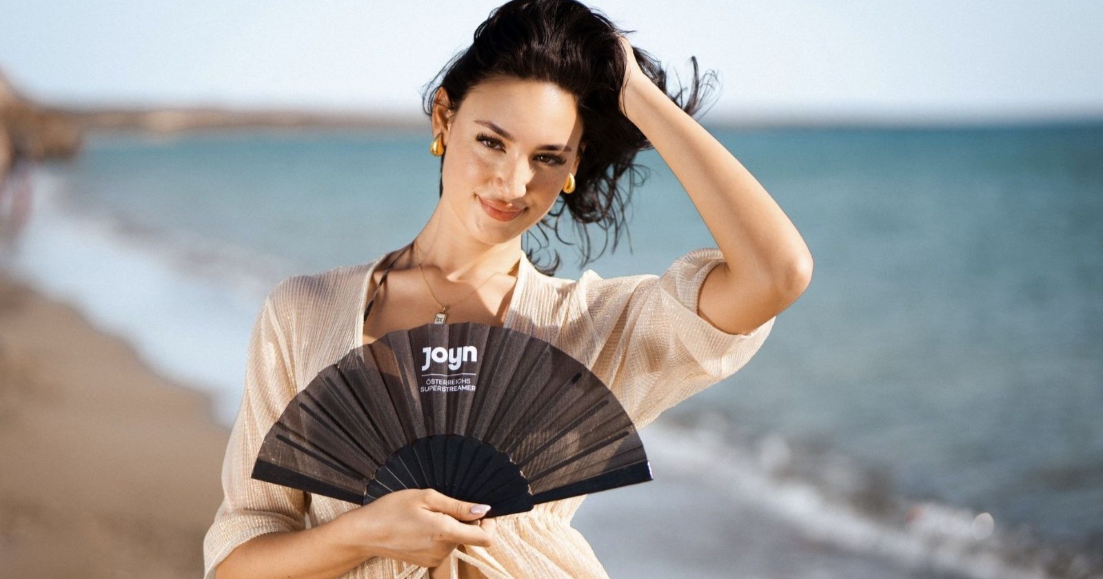 Zoe mit einer Fächer auf dem Strand