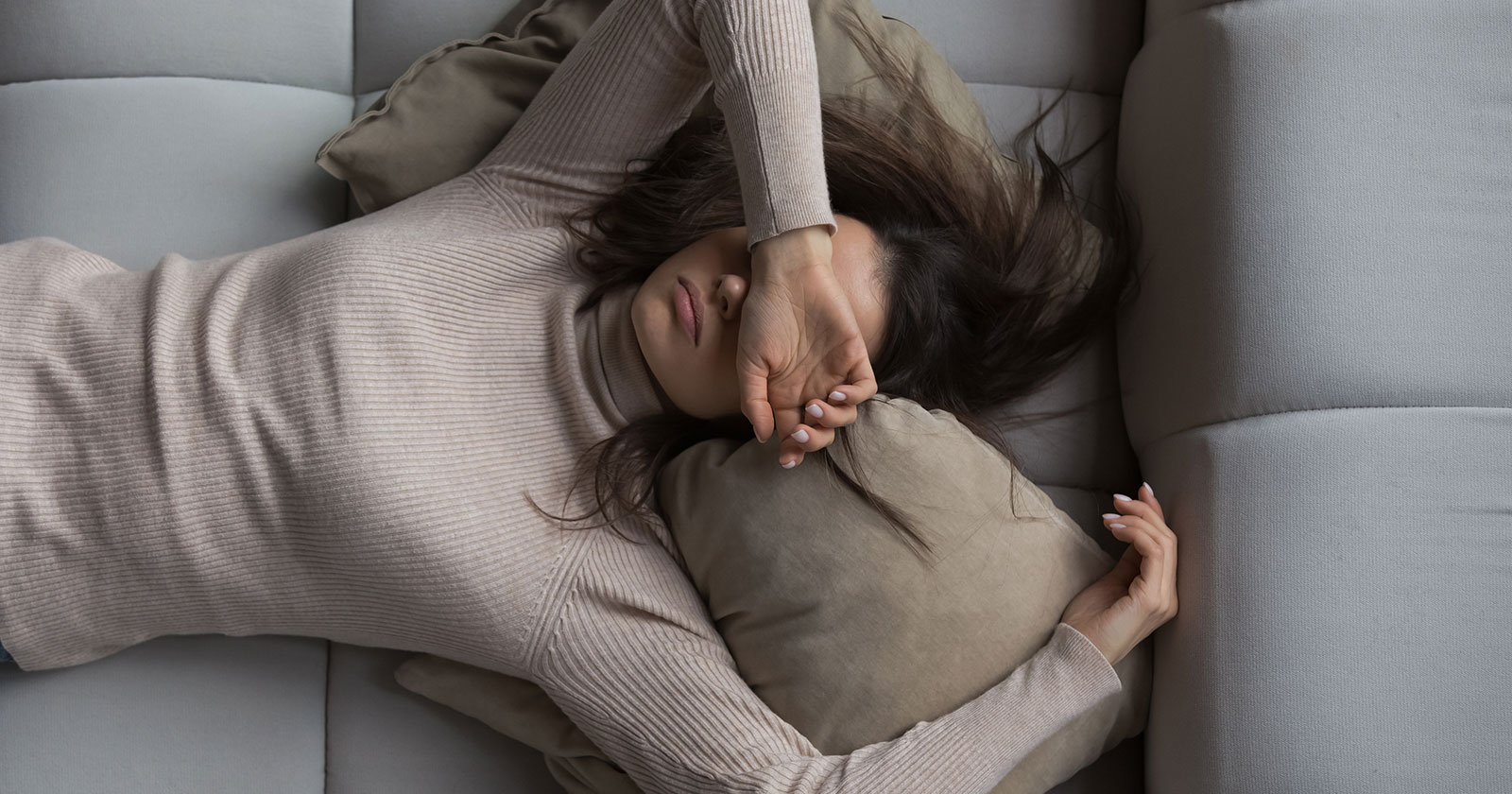 Frau schläft auf der Couch | Credit: iStock.com/fizkes