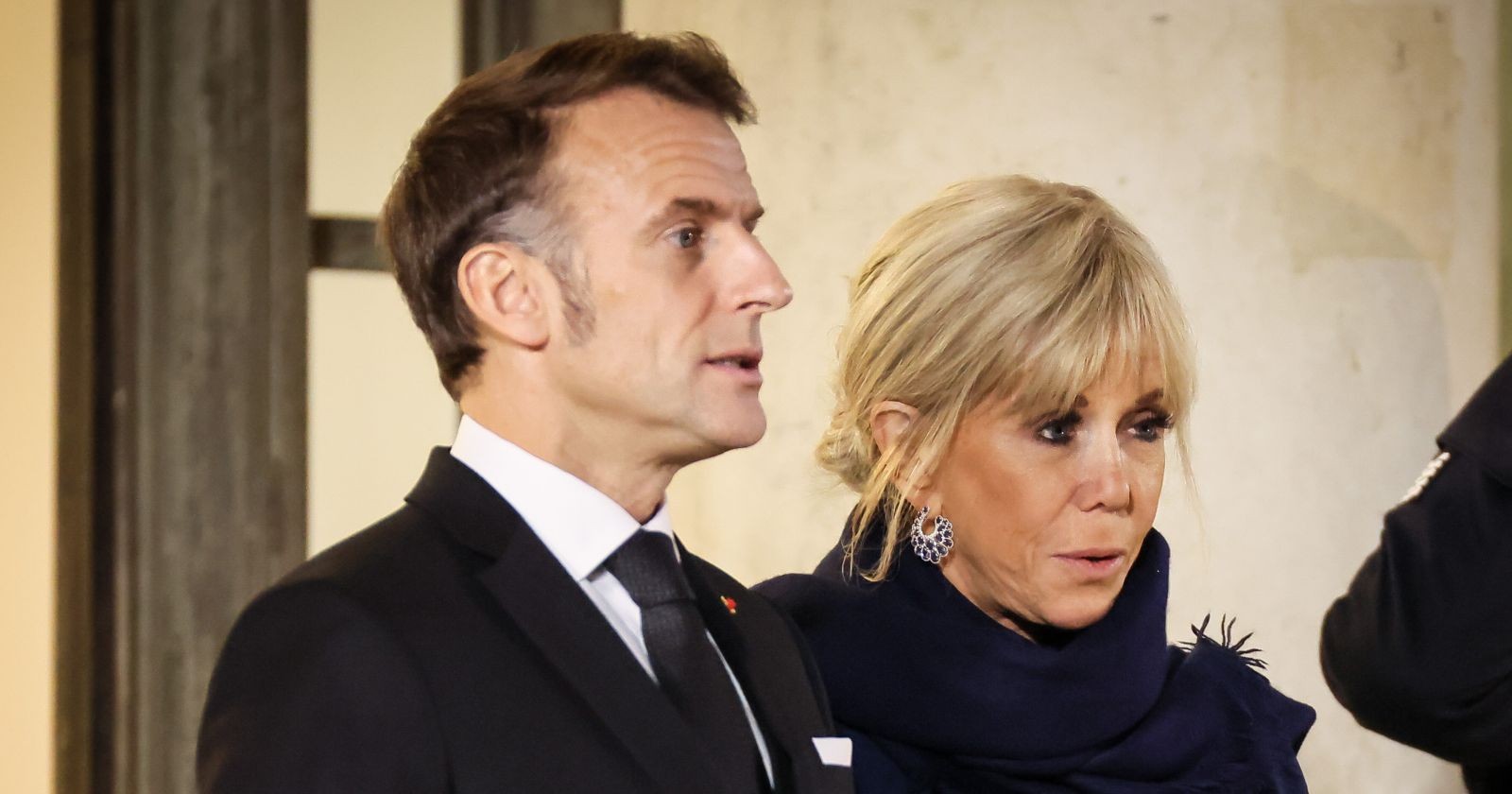 Emmanuel Macron und Brigitte Macron stehen nebeneinander bei einem offiziellen Termin in Paris; Brigitte Macron wirkt ernst, ihr Mann schaut nach vorn. Mit ihrem "sales connes"-Sager (dreckige Schlampen) sorgt sie für heftige Kritik
