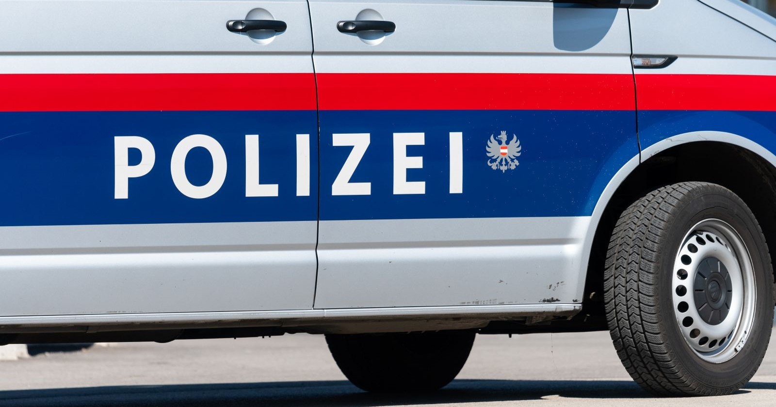 Seitenansicht eines österreichischen Polizeifahrzeugs mit der Aufschrift „POLIZEI“ in blauer und roter Lackierung. Die Beamten konnten nach dem Erkennen des SOS-Zeichen schnell eingreifen.