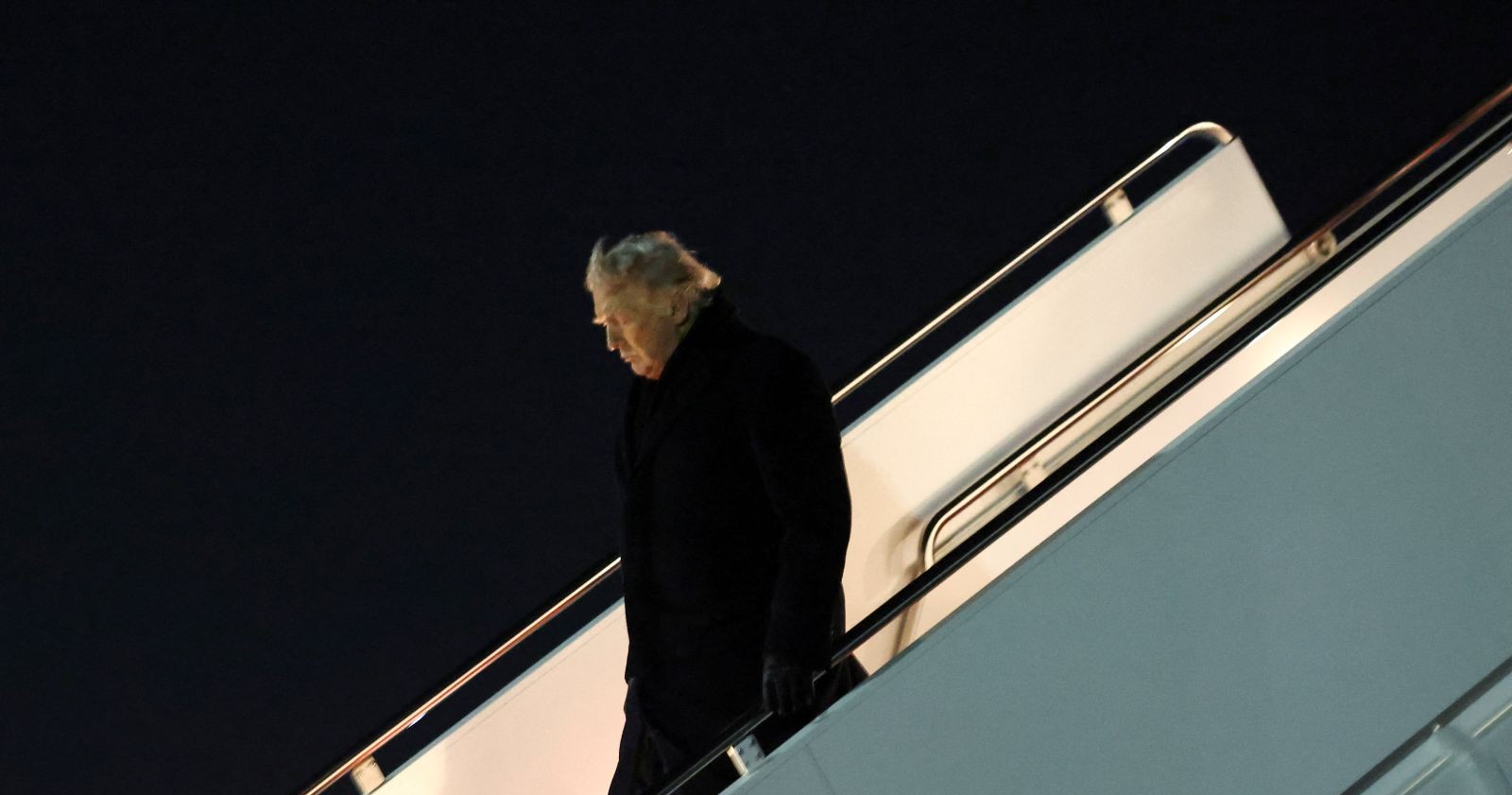 Donald Trump verlässt bei Nacht eine Flugzeugtreppe nach dem Air-Force-One-Zwischenfall auf dem Weg zum Weltwirtschaftsforum in Davos.