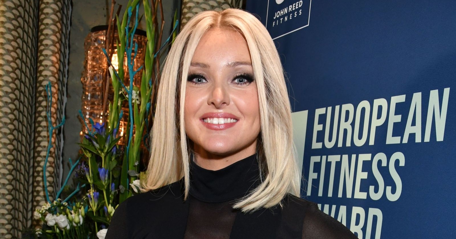 Patrice Aminati lächelt in einem schwarzen Kleid