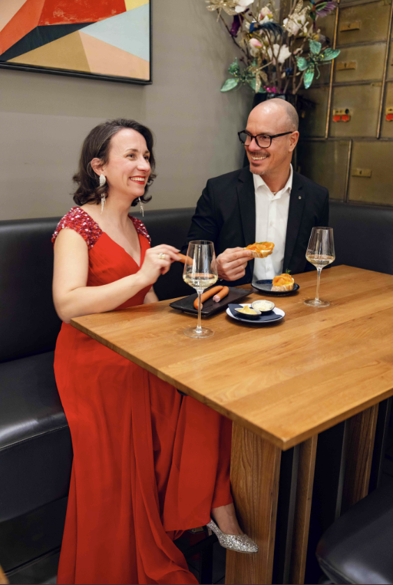 Frau in rotem Kleid und Mann in Anzug/ Interspar hat ein Opernball-Event organisiert im "das Mezzanin"