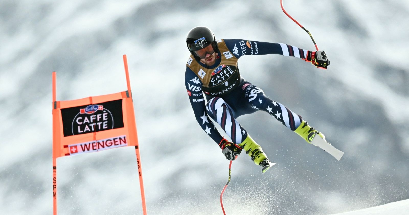 US-Abfahrstläufer Bryce Bennett in voller Fahrt bei der Wengen-Abfahrt auf der Lauberhorn-Strecke in der Schweiz, umgeben von Schnee und Torstangen.