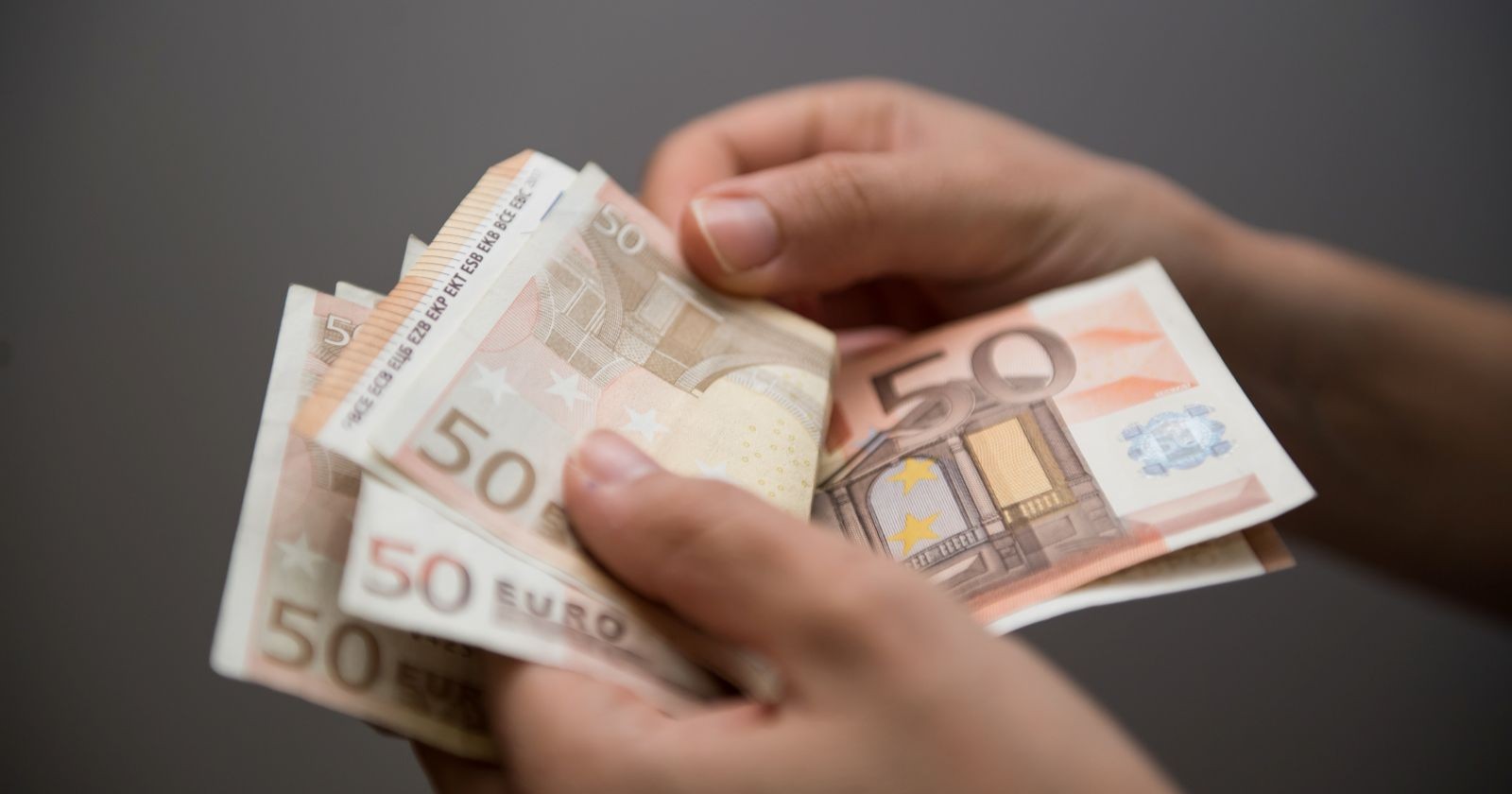 Hände die mehrere 50-Euro-Banknoten halten