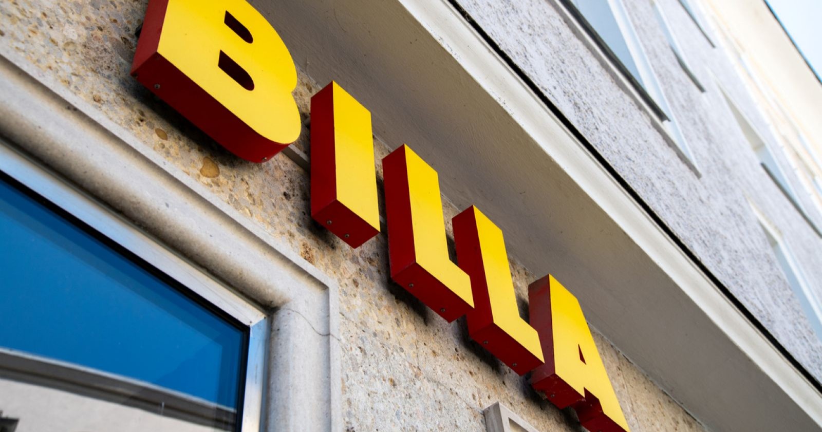 Billa-Filialschild mit gelb-rotem Logo an einer Hausfassade in Österreich  – Themenbild für das Aus der Rabatt-Pickerl von 50 Prozent