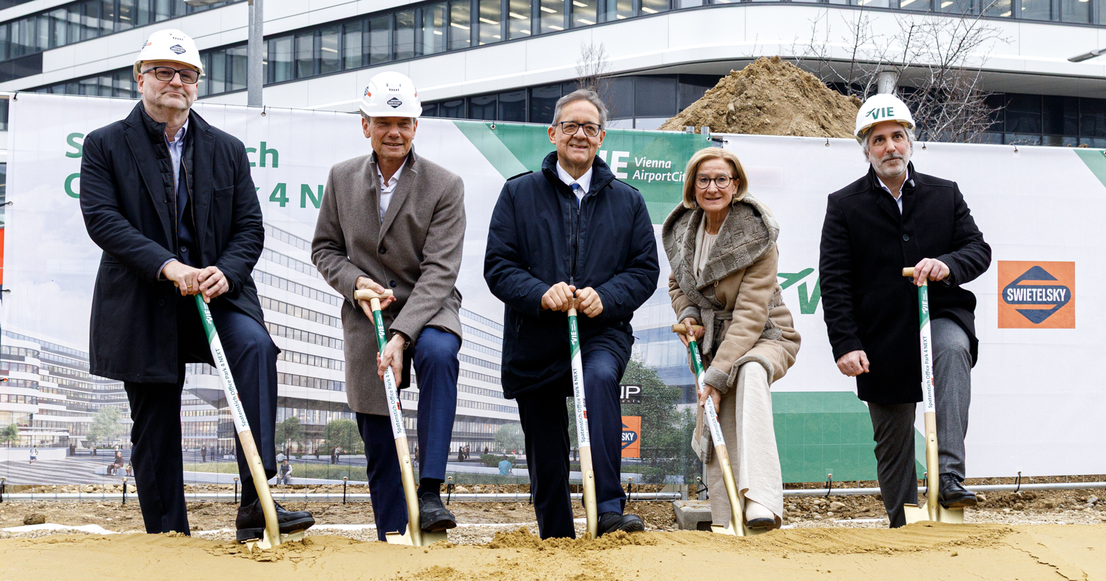 Fünf Personen mit Spaten bei der Flughafenbaustelle