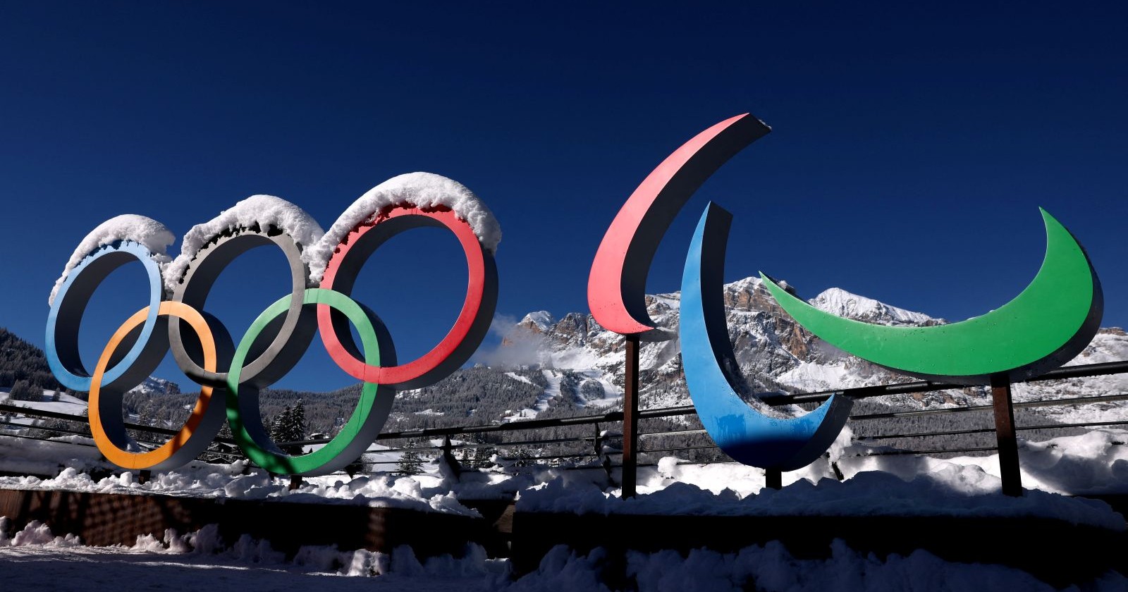 Olympische Ringe und Paralympics-Symbol stehen verschneit vor einer winterlichen Bergkulisse unter blauem Himmel/ Olympiasieger Michael Rösch spricht über Suizidgedanken und Depressionen
