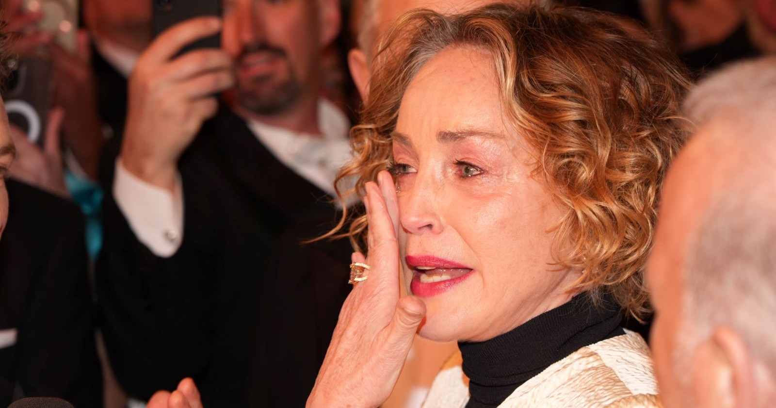 Sharon Stone am Wiener Opernball 2026, am roten Teppich gibt es im Interview Tränen, die Schauspielerin wischt sie mit der Hand aus dem Geischt.