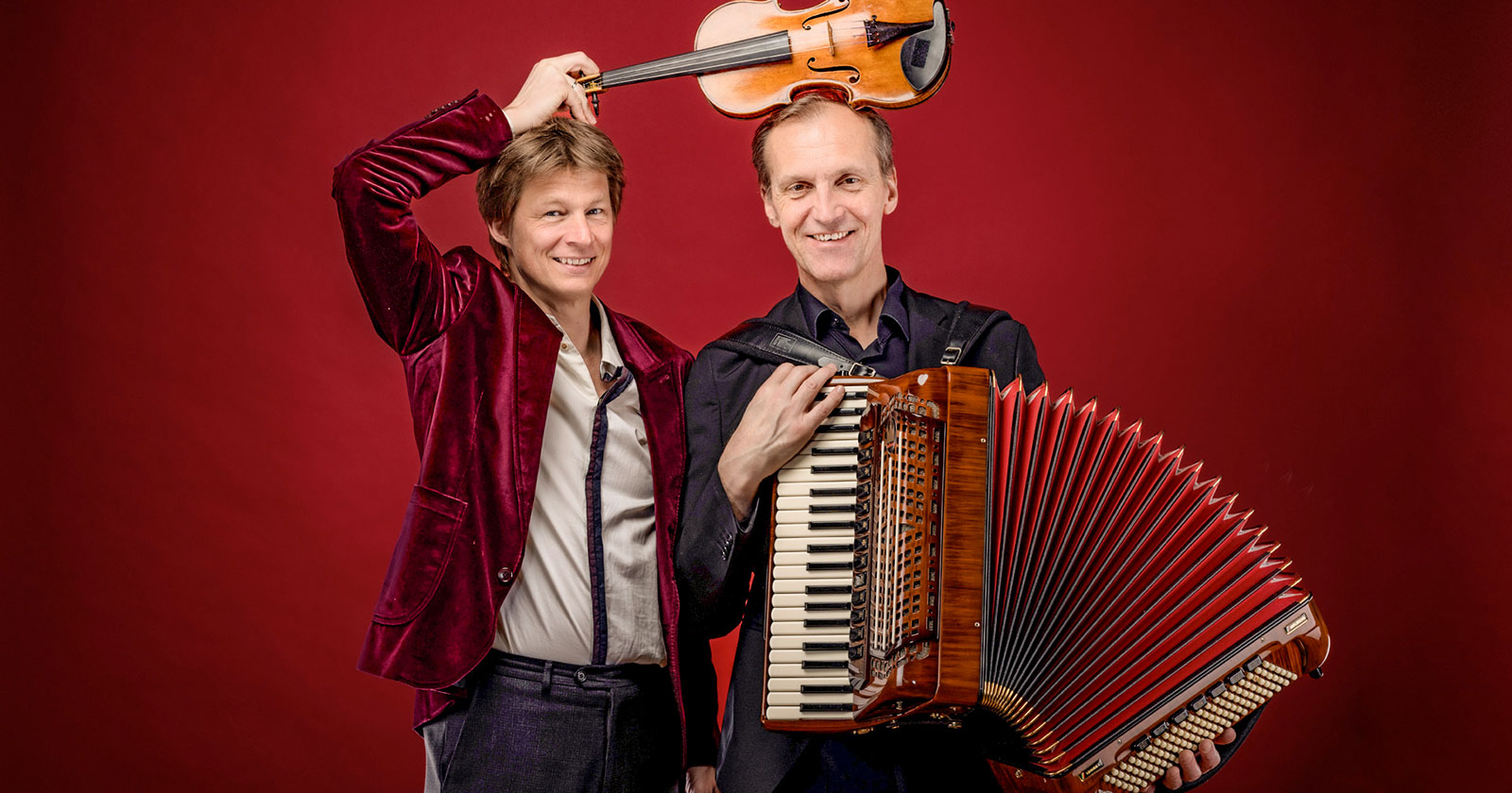 Zwei Musiker, einer hält ein Akordeon der andere eine Geige | Credit: Severin Koller