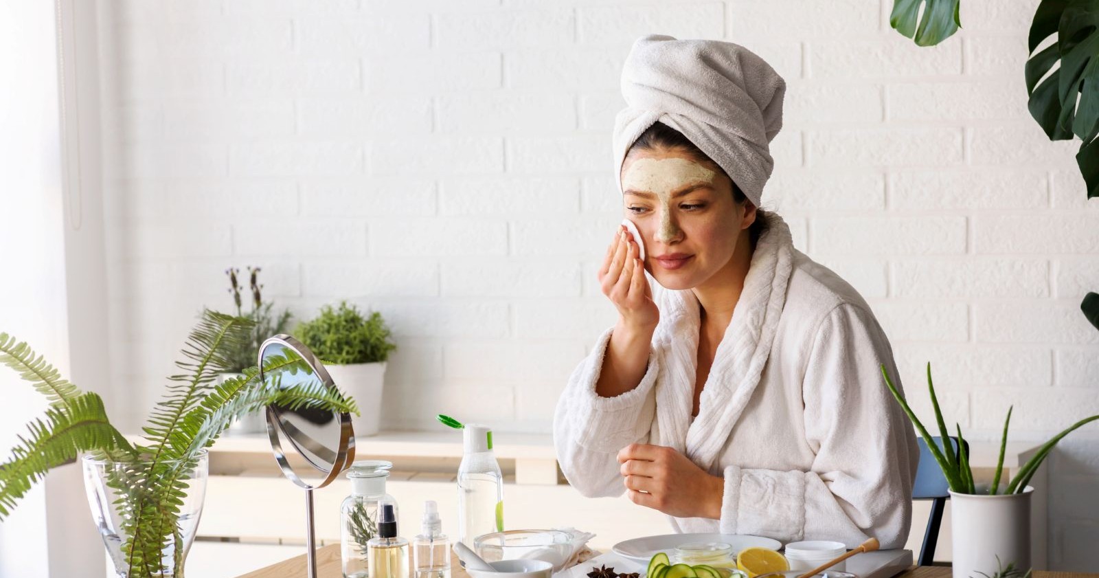 Eine Frau legt im Gesicht eine Creme auf.