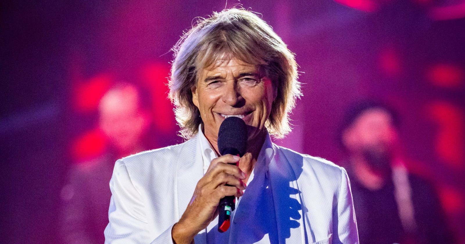 Hansi Hinterseer auf der Bühne mit Mikrofon; der Tiroler Sänger war einst Gast bei den Oscars und saß bei einer Oscar Verleihung in der ersten Reihe.