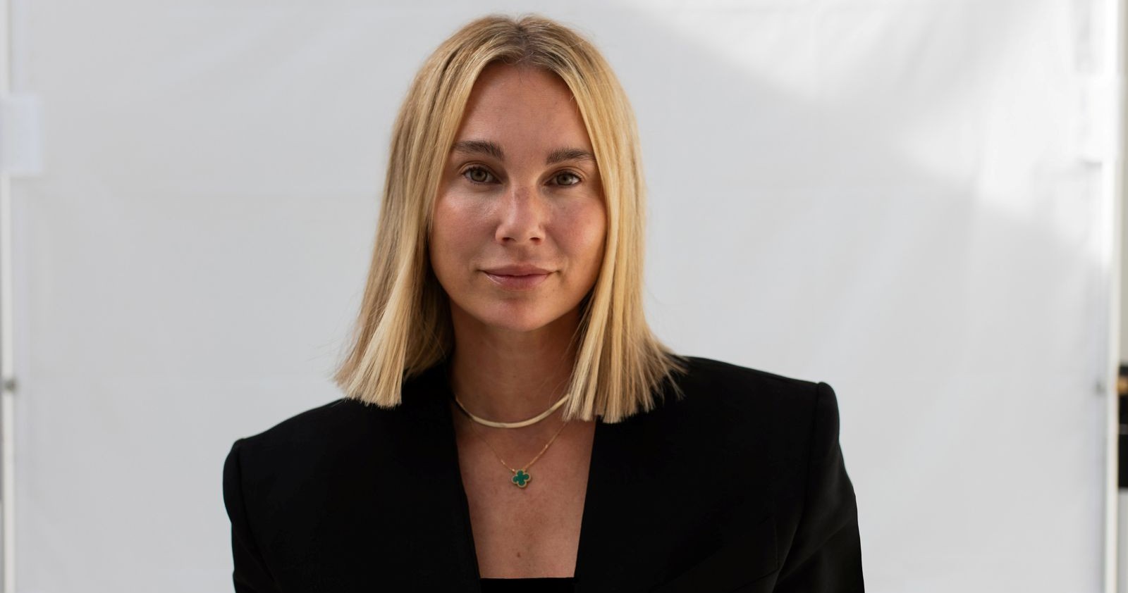 Eine Frau im schwarzen Blazer schaut in die Kamera