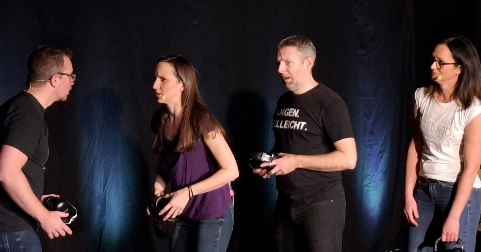 Mitglieder des Kabarett-Ensembles „Veni Vidi Witzki“ bei einer Szene aus dem Programm „Redebedarf?“ auf der Bühne.