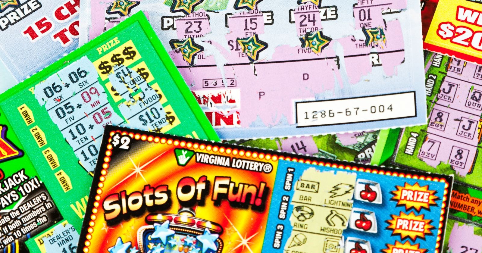 Mehrere bunte Rubbellose und Lotterie-Scratchcards liegen übereinander – Symbolbild für einen Millionengewinn durch ein Rubbellos.