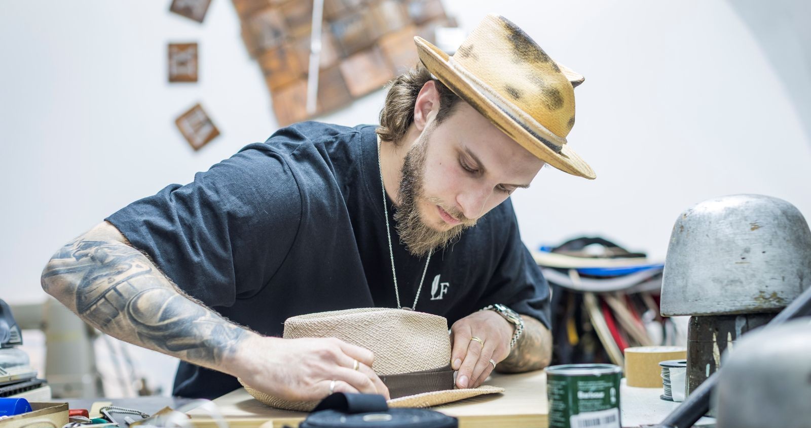 Ein junger Mann stellt einen Hut her.