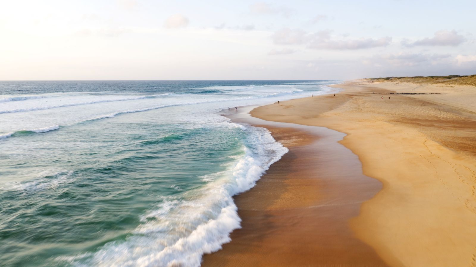 Ein weiter Strand mit goldenem Sand.