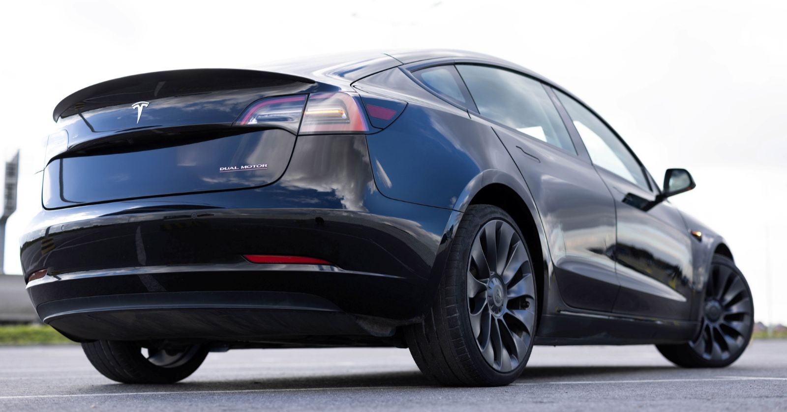 Tesla Model 3 von hinten auf der Straße mit Fokus auf Design und Karosserie, Symbol für wachsende Konkurrenz durch chinesische Elektroautos