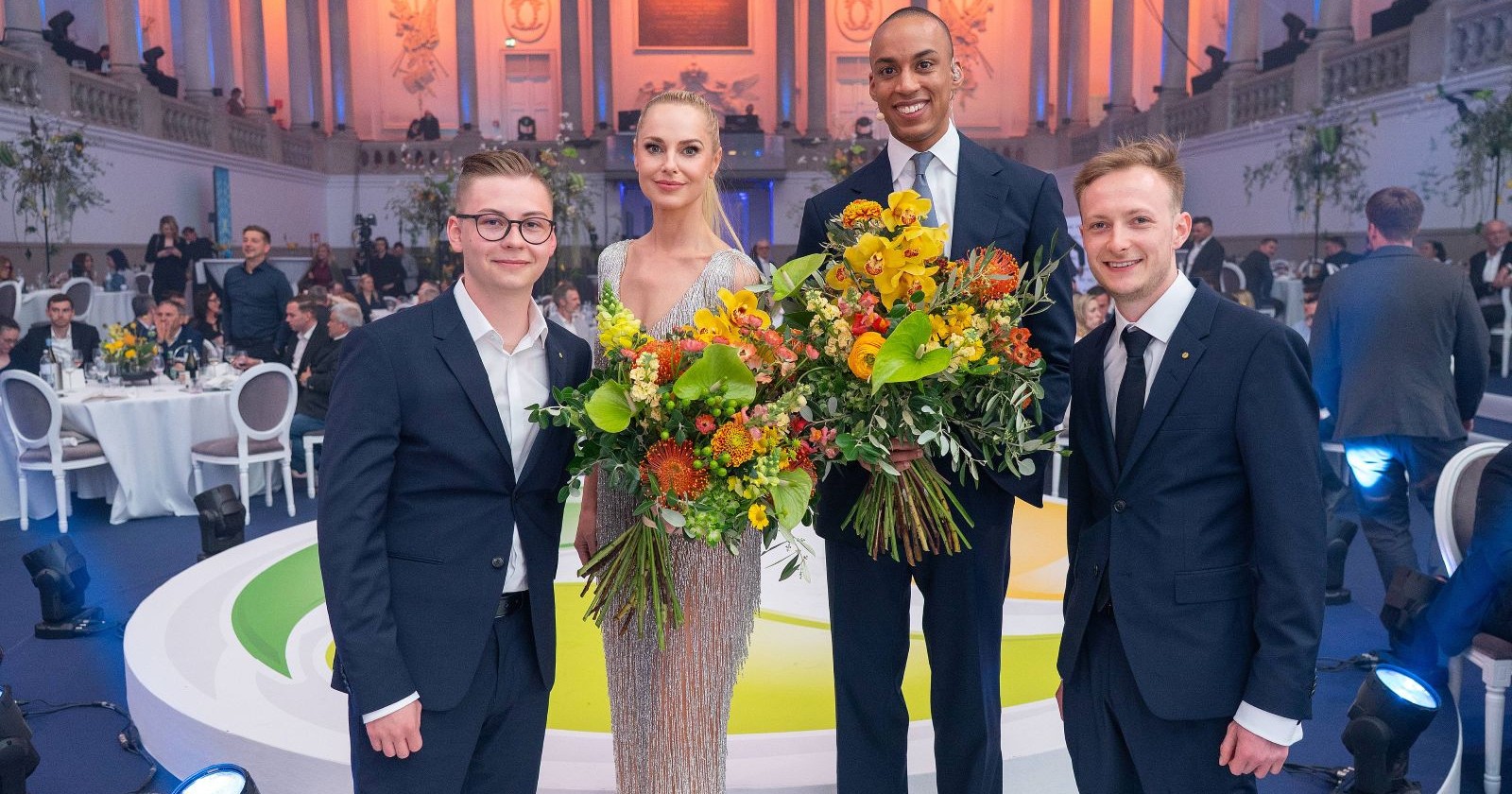 Gruppenbild mit Blumensträußen in den Händen der Moderatoren