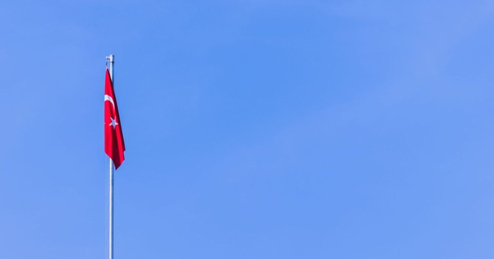 Türkische Flagge vor blauem Himmel – Symbolbild zum Amoklauf an einer Schule in der Türkei