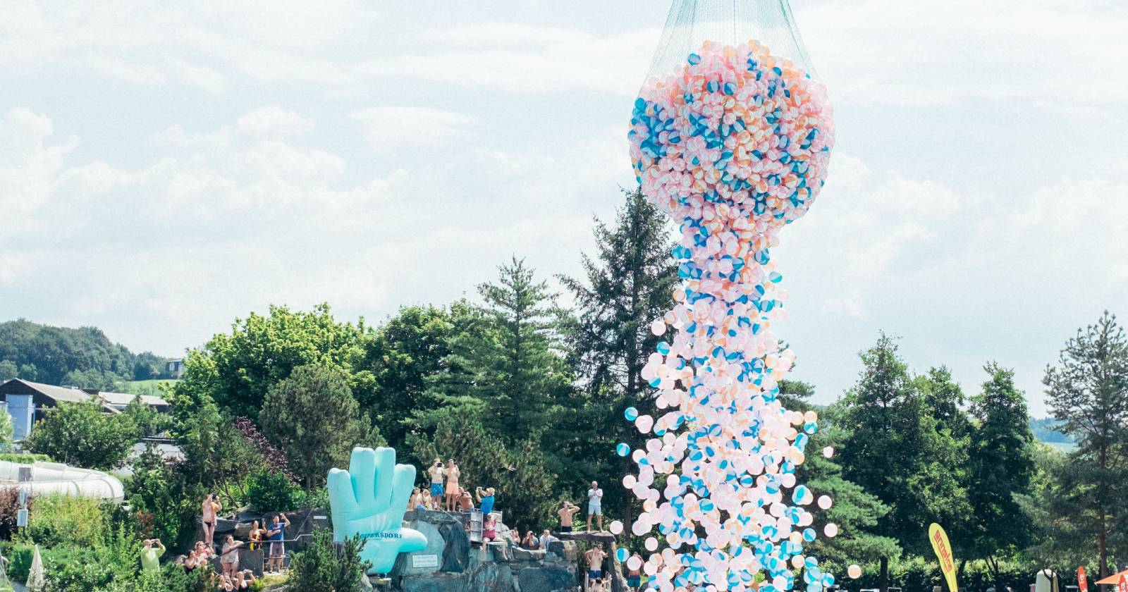 Es regnet farbenfrohe Wasserbälle in ein Wasserbecken im Zuge des #WeAreWater-Fest der Therme Loipersdorf