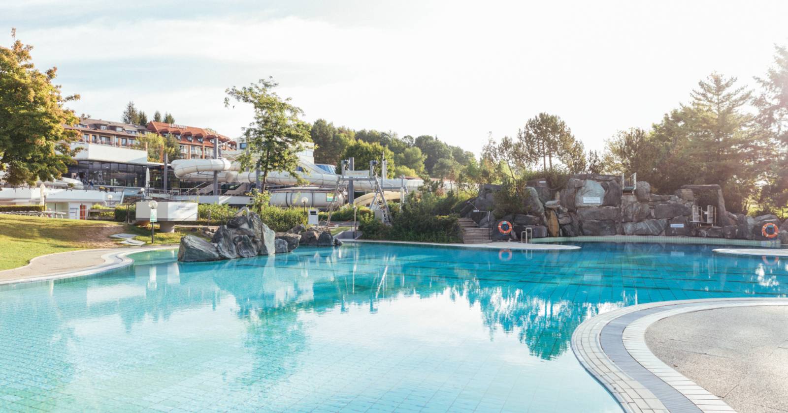 Freibereich der Therme Loipersdorf, Abbildung des Pools und der Anlage vor einem blauen Himmel