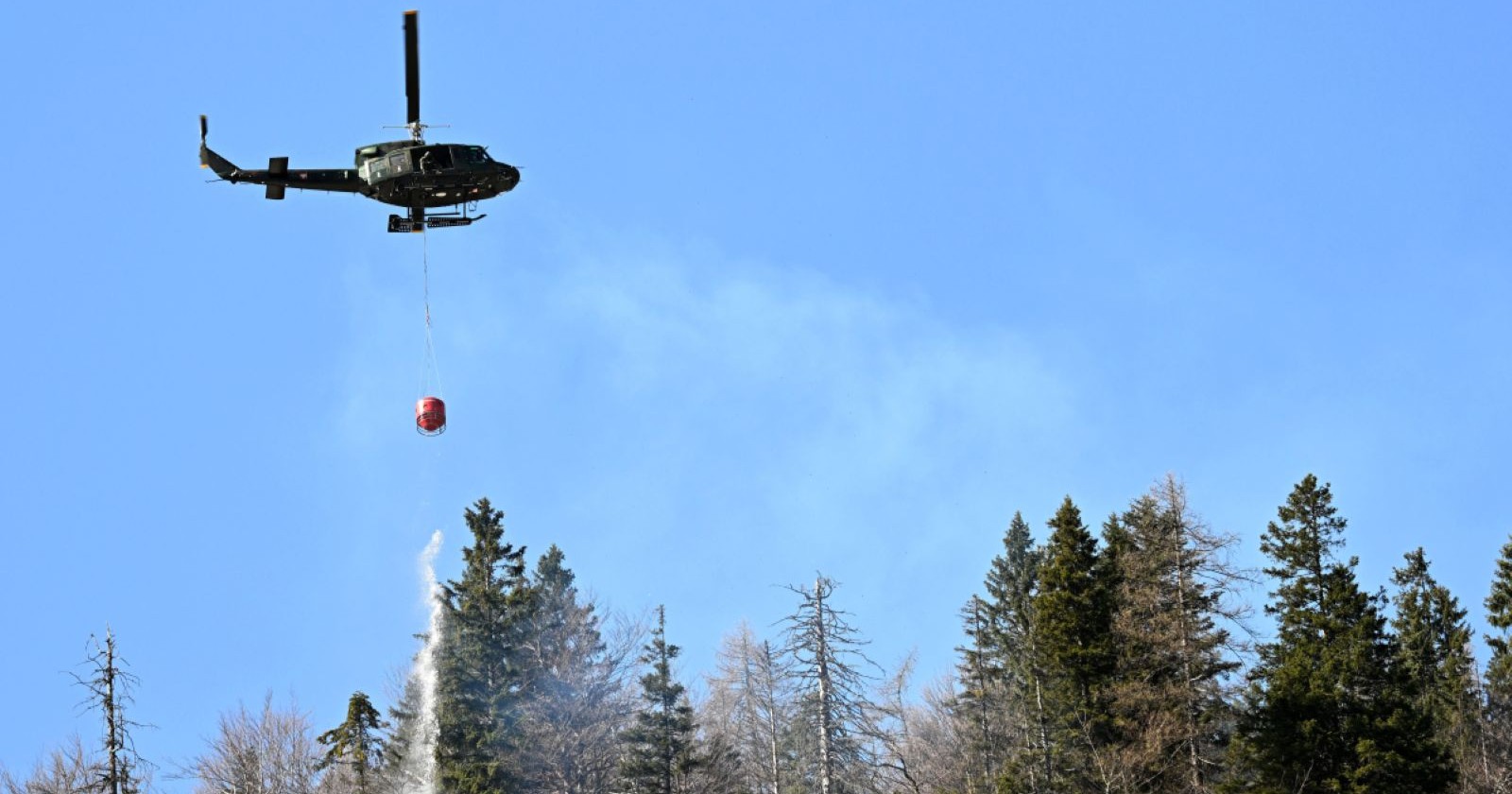 Hubschrauber löscht einen Waldbrand