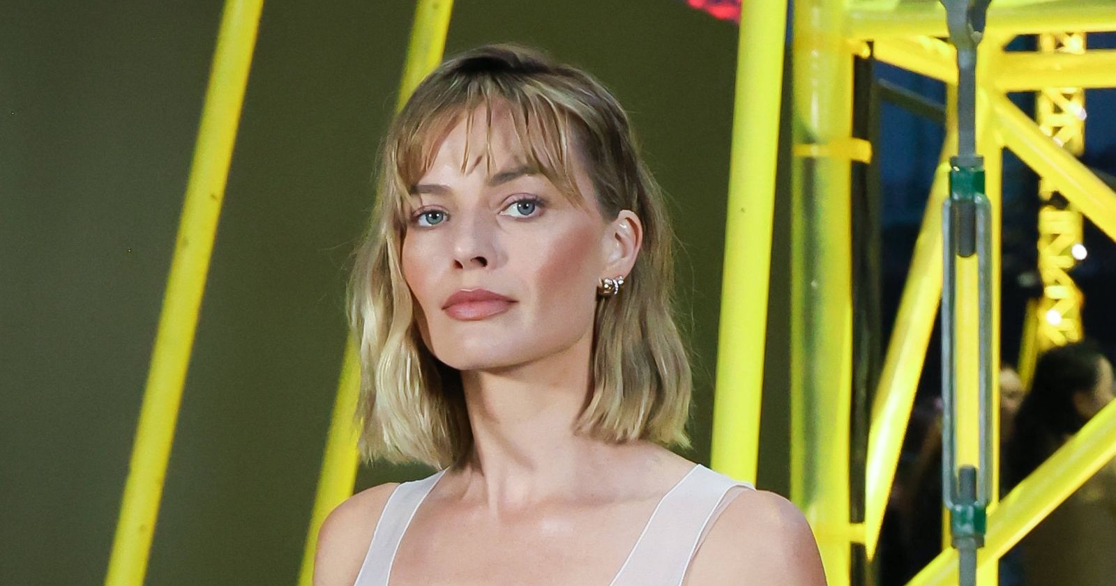 Margot Robbie mit natürlichem Glow und ebenmäßiger Haut als Beispiel für dezente Beauty-Treatments