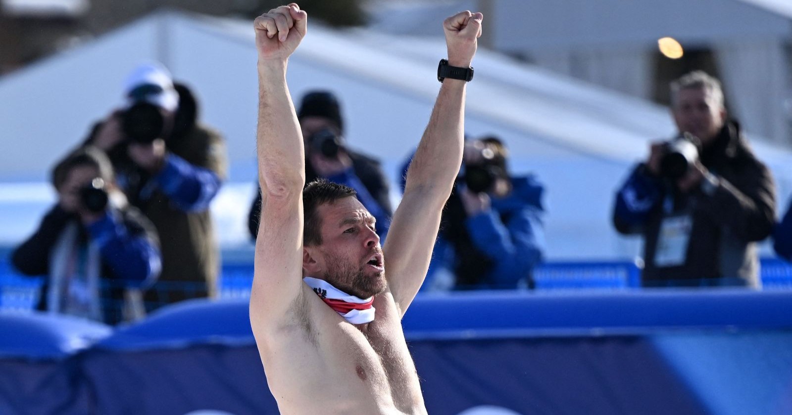 Benjamin Karl jubelt mit nacktem Oberkörper über seine Goldmedaille im Snowboard-Parallel-Riesenslalom bei Olympia 2026 in Livigno.