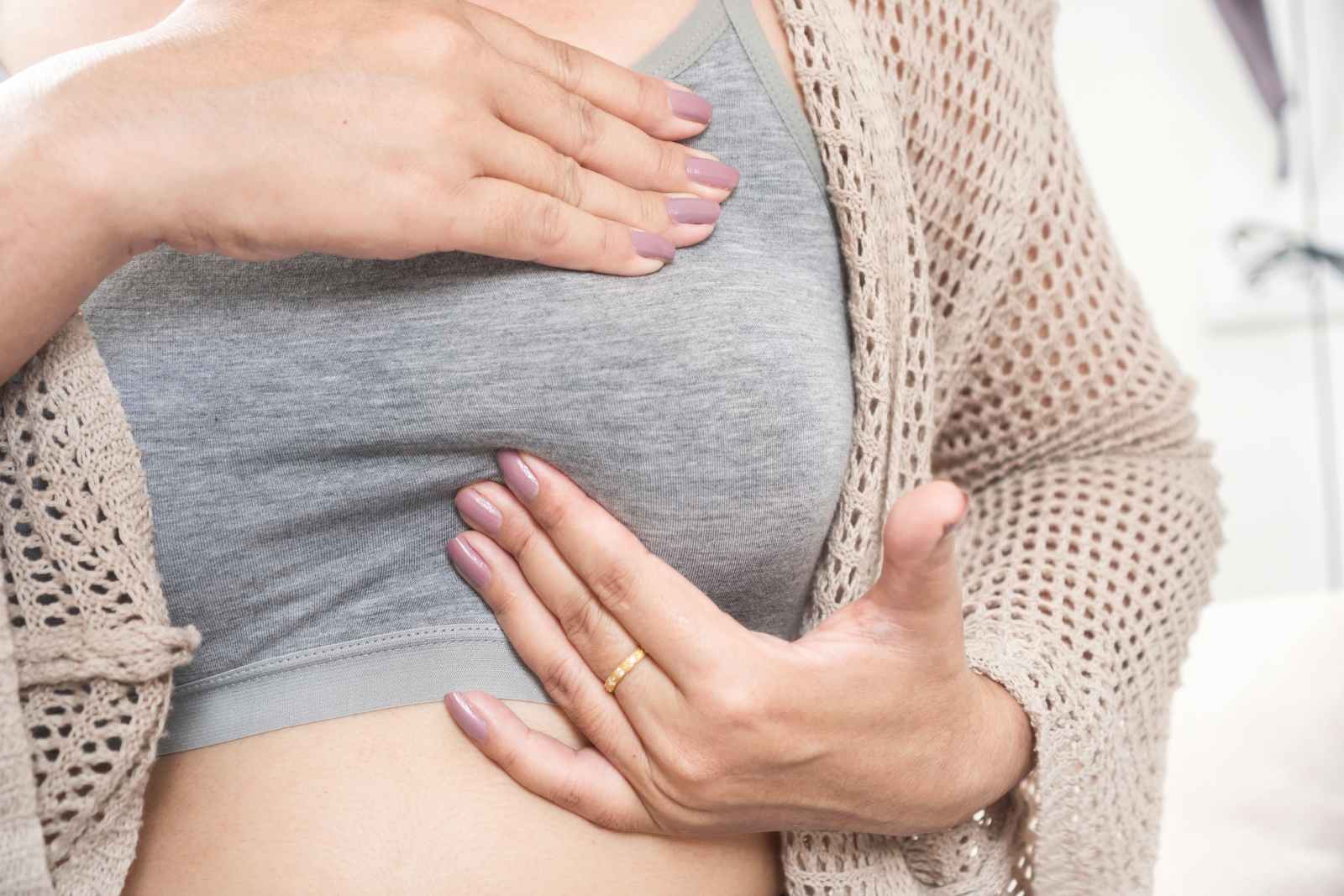 Frau tastet ihre Brust zur Selbstuntersuchung ab