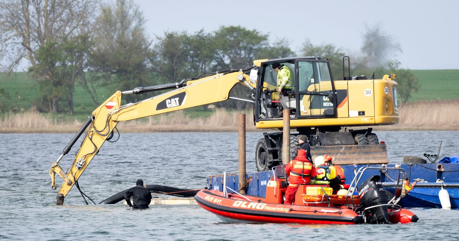 Bagger und Rettungsteam arbeiten im Wasser an der Rinne für die Befreiung von Buckelwal Timmy vor der Insel Poel