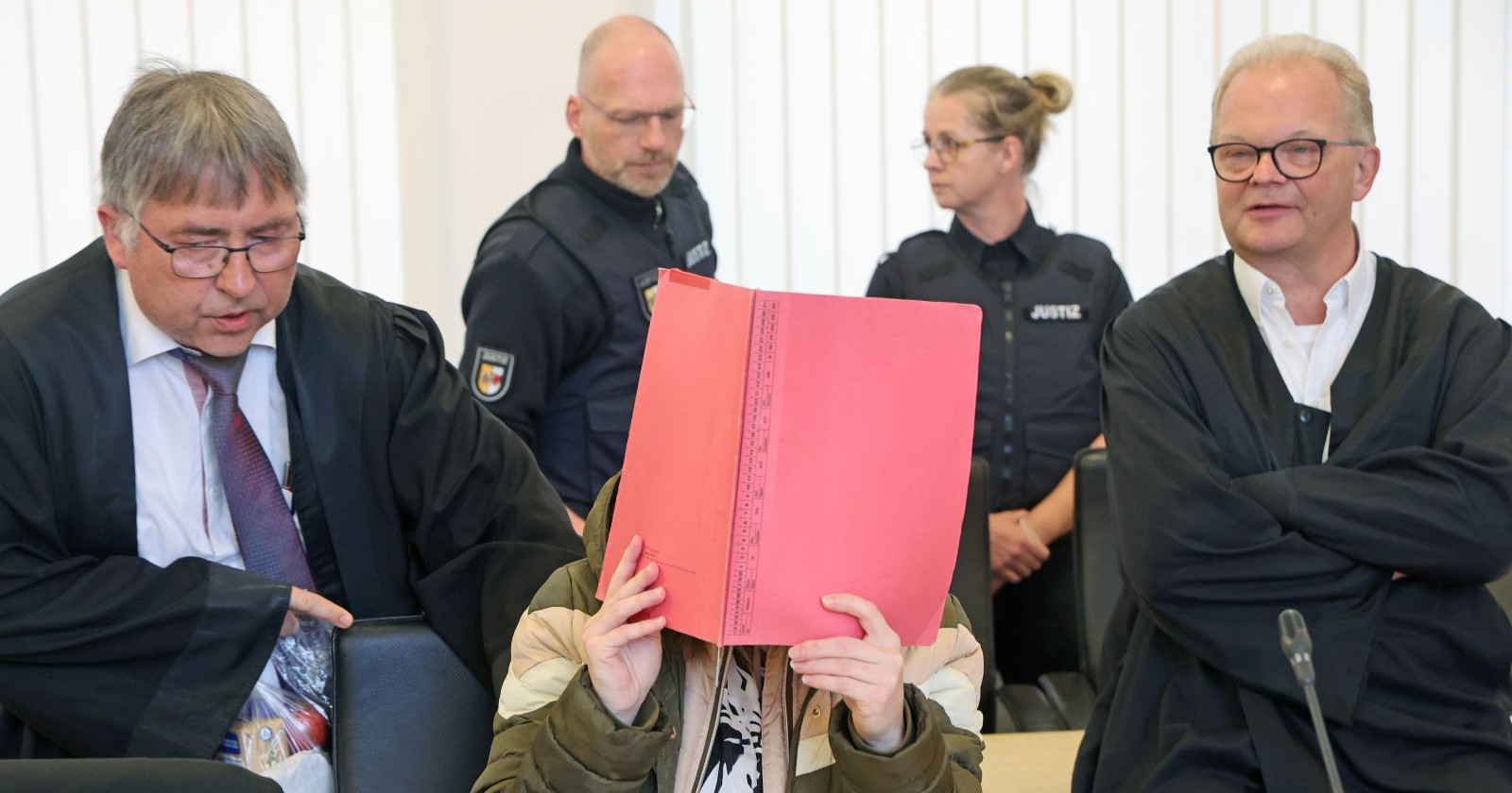 Angeklagte im Fall Fabian (8) aus Güstrow verdeckt ihr Gesicht im Gerichtssaal beim Prozessauftakt in Rostock