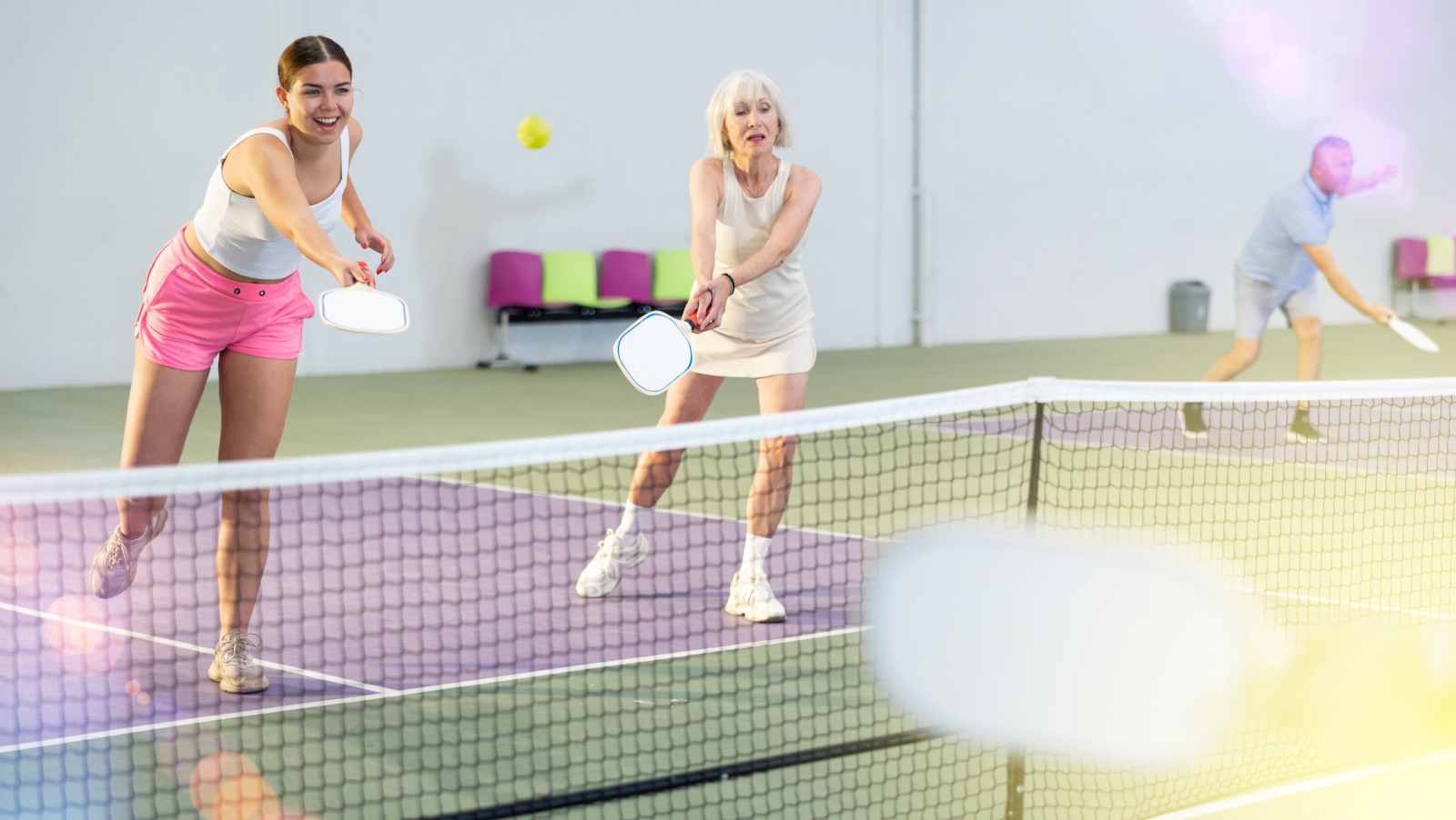 Zwei Frauen spielen Pickleball in der Halle, Trendsport für alle Altersgruppen