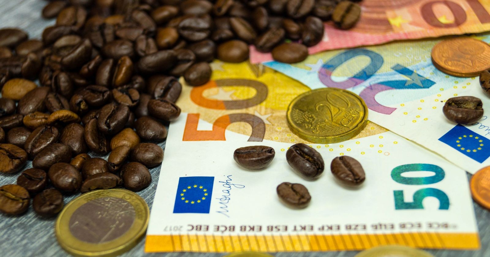 Kaffebohnen neben Euro-Banknoten als Themenbild für die gestiegenen Preise im Großhandel