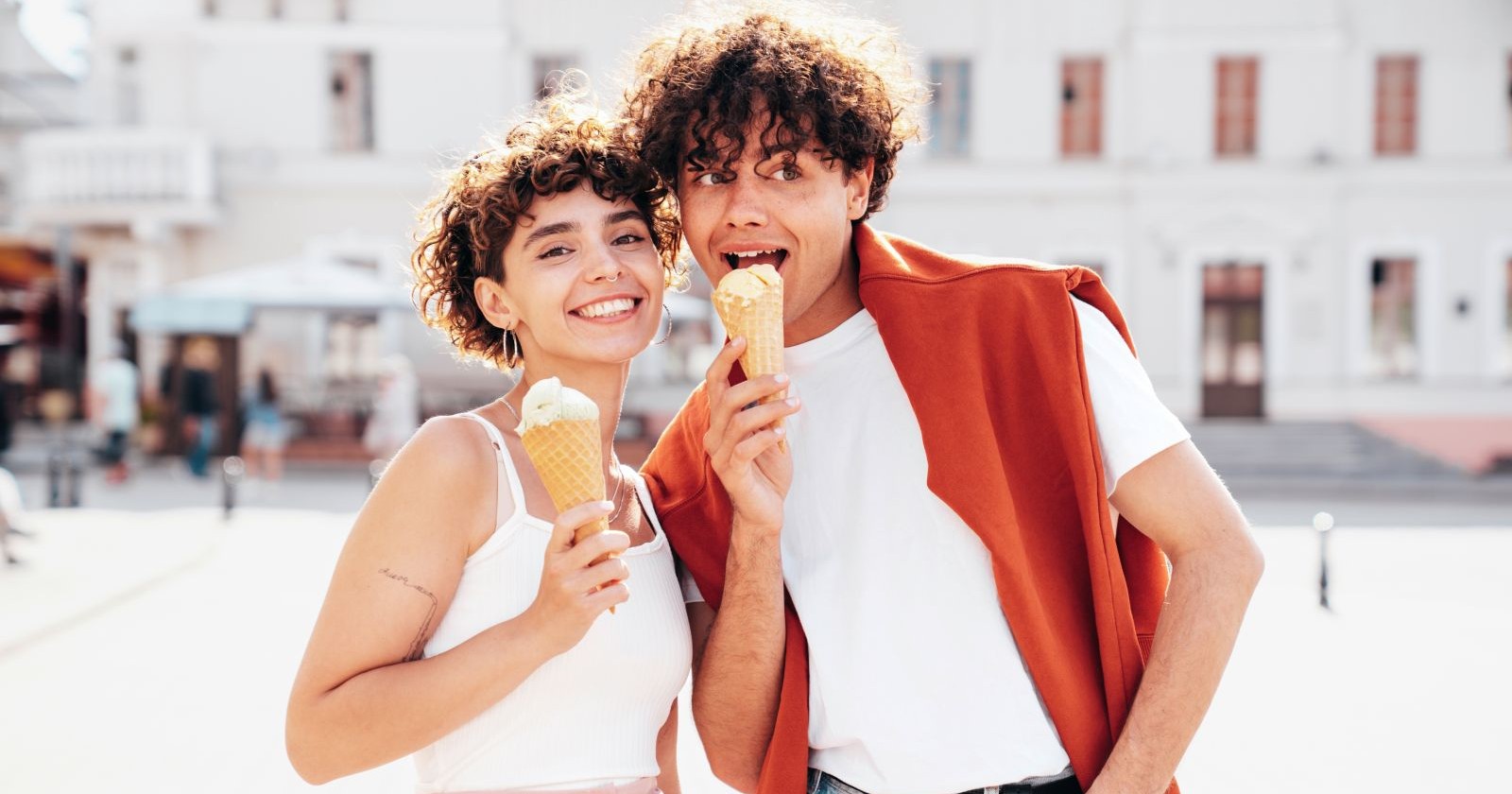 junger Mann und junge Frau in weißen Shirts und mit Eistüten