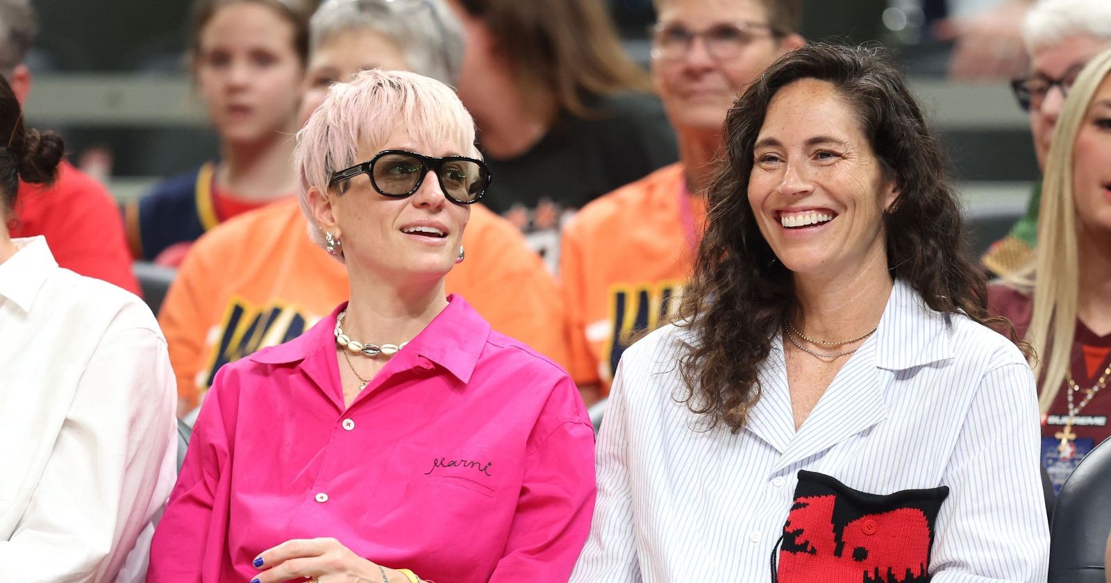 Megan Rapinoe und Sue Bird sitzen nebeneinander bei einem Event und lächeln, bevor sie ihre Trennung bekannt geben.