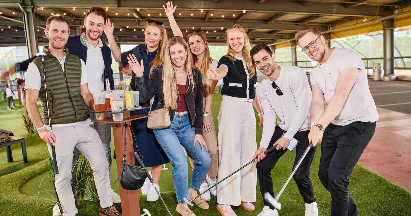 Teilnehmer beim Charity-Minigolf von Lions Club Traun und Weekend Magazin in Leonding mit Schlägern und Getränken