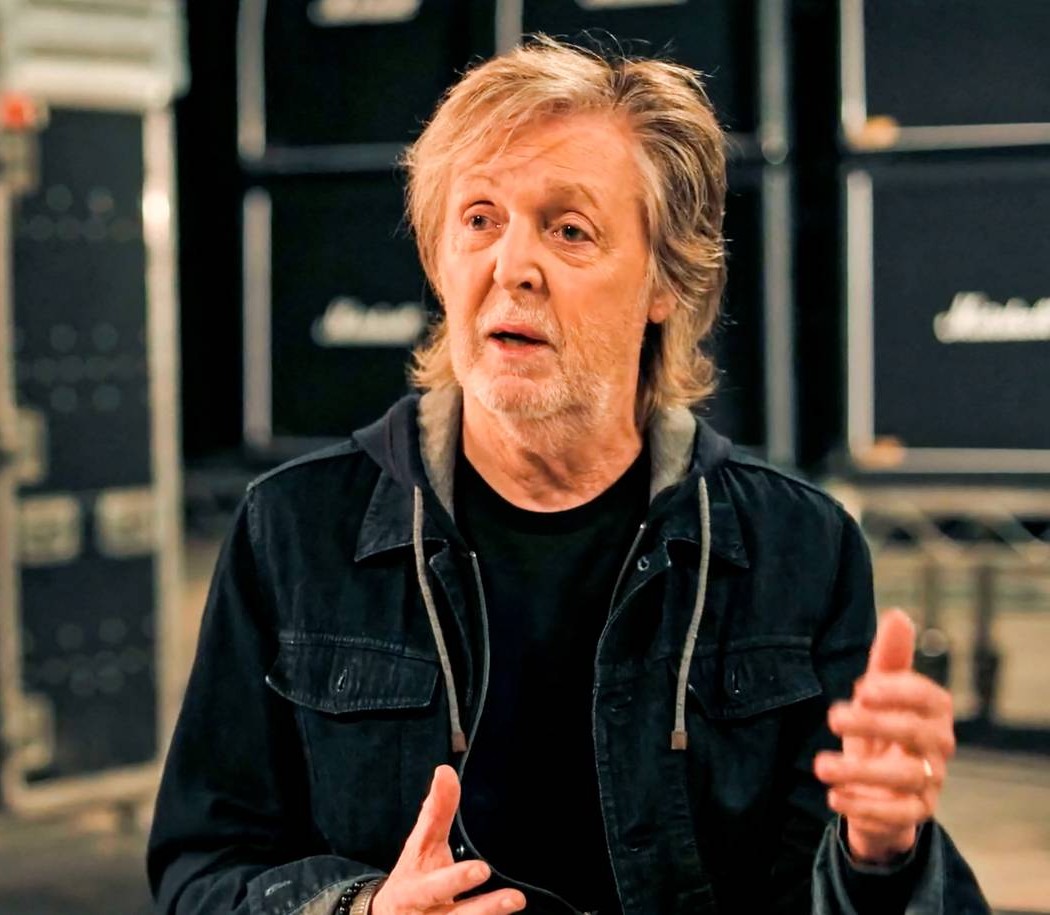 Paul McCartney in dunkler Kleidung bei einem Interview oder Proberaum