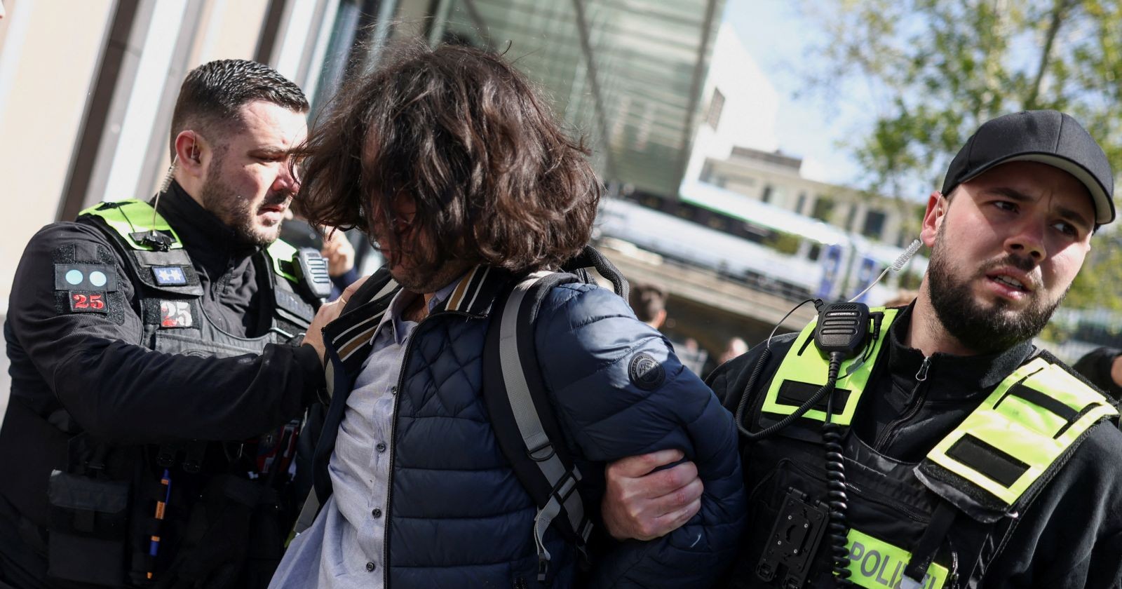 Polizisten führen Tatverdächtigen nach Angriff auf Reza Pahlavi vor der Bundespressekonferenz in Berlin ab