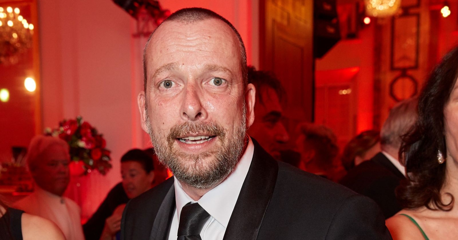 Robert Kratky bei einem Event in eleganter Abendgarderobe, aufgenommen in einem festlich beleuchteten Innenraum mit rotem Licht/Kratky bringt eine Bipgrafie auf den Markt