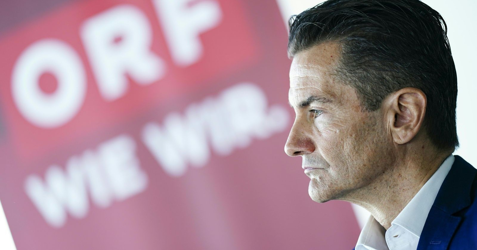 Roland Weißmann blickt vor dem ORF-Logo ernst zur Seite, nachdem der Sender ihn trotz Entlastung durch die Untersuchung gekündigt hat.